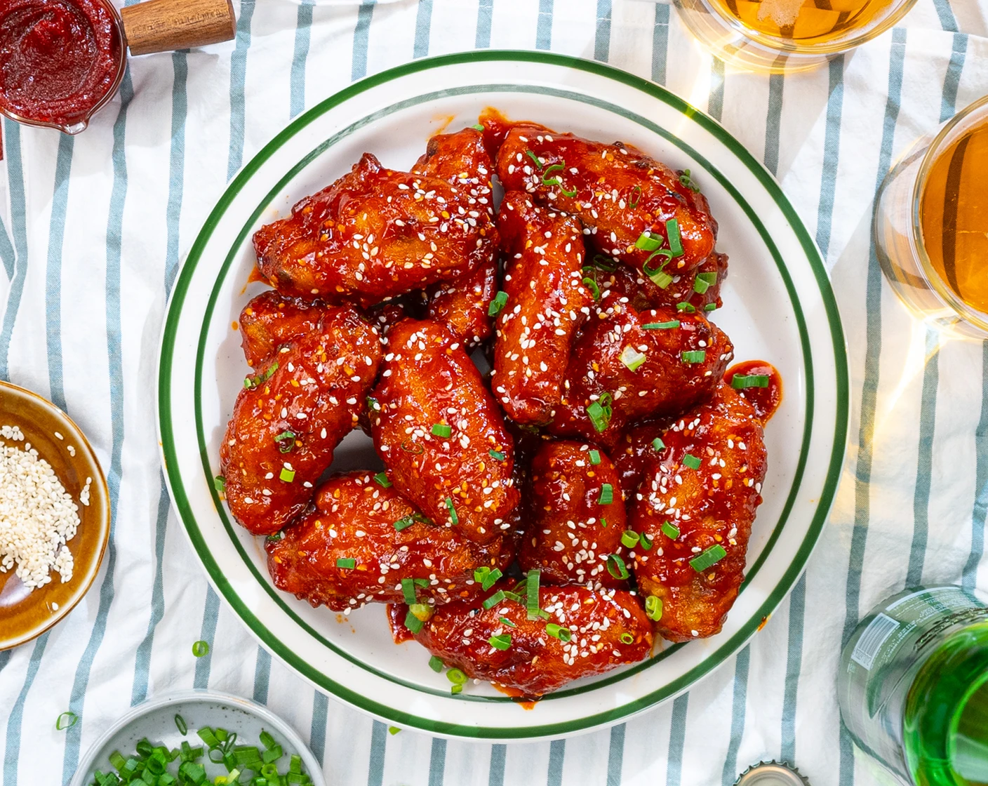 Plate of gochujang-glazed Korean fried chicken wings with sesame seeds and scallions